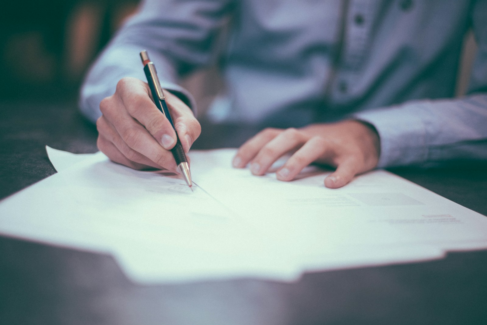 man writing on an auto insurance policy